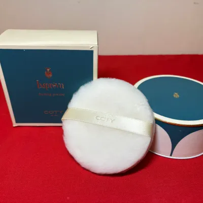Vintage Coty Imprévu dusting powder set including the original outer box, decorative round container, and fluffy white powder puff.