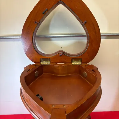 Heart-shaped wooden display side table with a hinged glass-top lid opening to a shallow storage compartment.