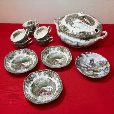 Vintage Currier & Ives transferware tureen, teacups, and small bowls featuring scenic rural winter landscapes.