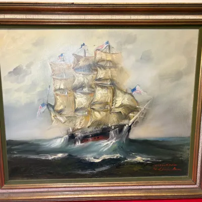 Framed oil painting depicting the USS Constitution sailing through rough seas, signed by the artist in the lower right corner, housed in...