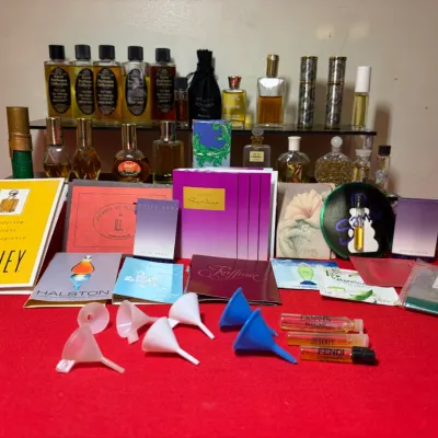 Large collection of vintage perfume bottles, fragrance samples, promotional brochures, and mini plastic funnels.