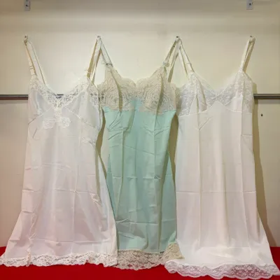 Trio of vintage women's full slips, featuring lace-trimmed necklines and hems in white and light mint green.