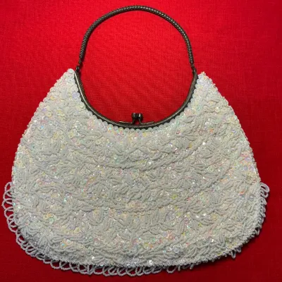 Vintage white beaded and sequined evening bag featuring a scalloped beaded fringe and a metal kiss-lock handle.