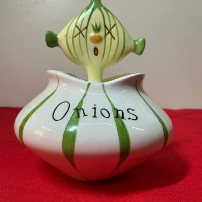 Vintage ceramic onion cellar with a whimsical anthropomorphic onion lid, featuring green stripes and 'Onions' labeled across...