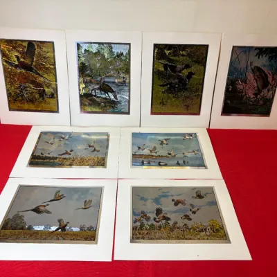 Set of eight vintage matted metallic foil wildlife prints featuring hunting and nature scenes with birds, deer, and fish.