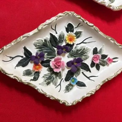 Vintage diamond-shaped ceramic trinket dish featuring applied 3D floral accents and a scalloped gold-tone rim.