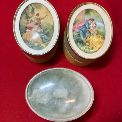 Set of three vintage oval trinket boxes, including two with printed Fragonard-style romantic courting scenes under convex glass.