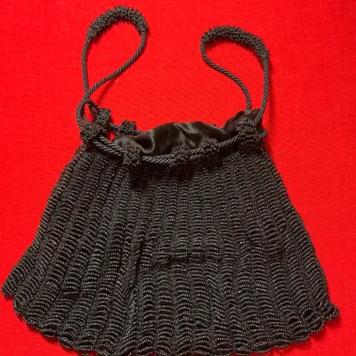 Vintage black beaded drawstring purse with dual beaded shoulder straps and satin inner lining.