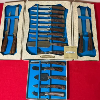 Vintage Regent Sheffield cutlery sets with faux wood handles, housed in original display boxes with blue velvet-style inserts.