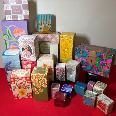 Collection of vintage Avon beauty products and fragrance boxes featuring colorful 1960s and 1970s graphic packaging designs.