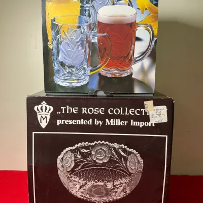 Two boxed glass serving items from 'The Rose Collection' by Miller Import, including a set of glass mugs and a 10-inch pedestal...