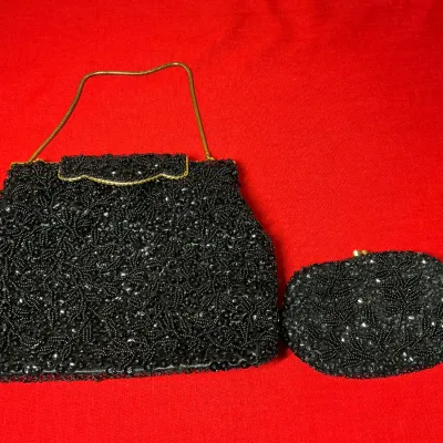 Vintage black beaded handbag and matching change purse set with gold-tone chain strap and hardware.