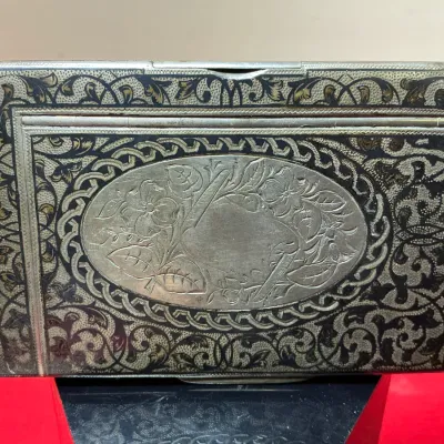 Antique silver niello card or cigarette case featuring intricate scrollwork decoration and a central oval medallion with engraved floral...