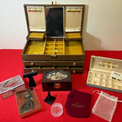 Collection of vintage jewelry boxes and accessories, featuring a large multi-tiered wood-grain chest with a mirror, a Mele jewelry case,...