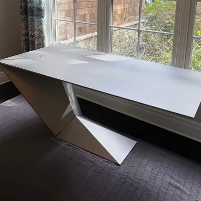 Sale Photo Thumbnail #23: Modernist canted-base executive desk featuring a smooth light gray surface and integrated wire management port.