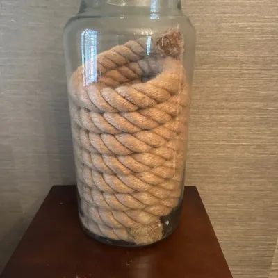 Sale Photo Thumbnail #20: Large clear glass apothecary jar filled with coiled natural fiber rope, suitable as a decorative accent piece.