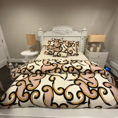 Sale Photo Thumbnail #9: Carved white painted bed frame featuring detailed finials and molding, dressed with a modern swirling graphic pattern duvet set and flanked by matching bedside tables with lamps.