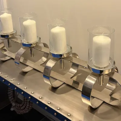Sale Photo Thumbnail #12: Contemporary polished chrome four-light candleholder centerpiece with clear glass hurricanes and unlit white pillar candles.