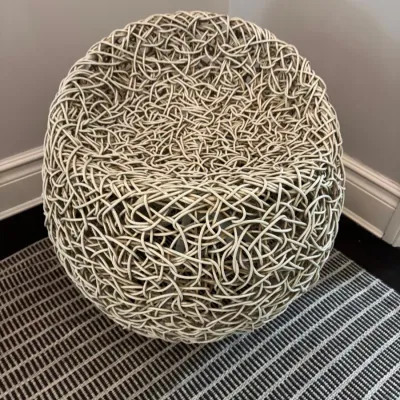 Sale Photo Thumbnail #63: Contemporary round woven rattan-style accent chair with an intricate, bird's-nest design.