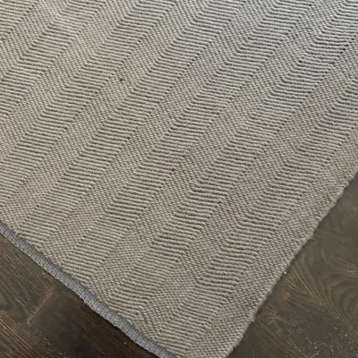 Sale Photo Thumbnail #29: Neutral gray woven area rug featuring a subtle chevron geometric pattern, displayed on dark hardwood flooring.
