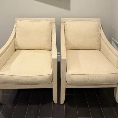 Sale Photo Thumbnail #2: Pair of contemporary accent armchairs with whitewashed wood frames and textured cream upholstered cushions.