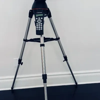 Sale Photo Thumbnail #34: Celestron NexStar computerized telescope mounted on an adjustable stainless steel tripod with hand controller accessory.