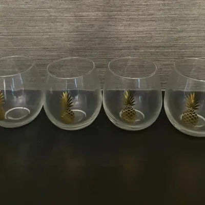 Sale Photo Thumbnail #74: Set of four stemless wine glasses featuring gold pineapple motifs.