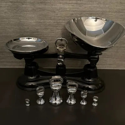 Sale Photo Thumbnail #69: Vintage black cast iron balance scale with polished chrome weighing pans and a matching set of chrome weights.