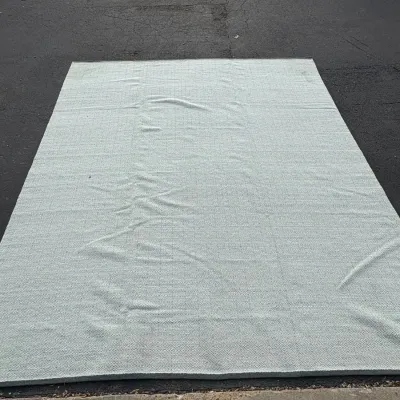 Sale Photo Thumbnail #76: Large light blue woven area rug featuring a subtle geometric diamond grid pattern, laid out outdoors.