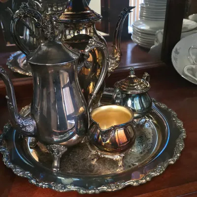 Sale Photo Thumbnail #49: Vintage ornate silver-plated tea and coffee service set with serving tray, featuring a gold-washed interior on the creamer and intricate scrollwork details.