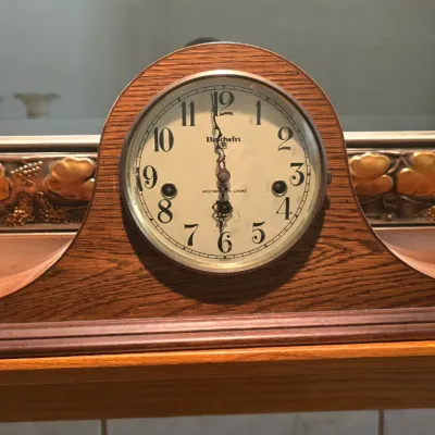 Sale Photo Thumbnail #84: Vintage Baldwin wooden mantel clock featuring a Westminster chime dial and an arched oak case.