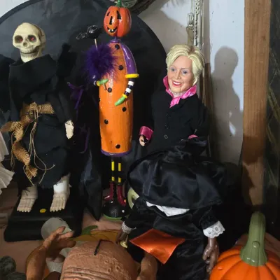 Sale Photo Thumbnail #18: Collection of Halloween decor and novelty figures, including a standing skeleton, pumpkin-headed figure, Hillary Clinton parody doll, and various spooks.