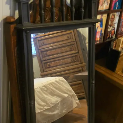 Sale Photo Thumbnail #52: Vintage dark painted wooden wall mirror featuring a carved pediment top with turned spindle details and a central finial.