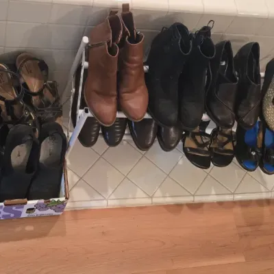 Sale Photo Thumbnail #66: A large collection of women's shoes and ankle boots organized in a cardboard box and on two metal wire shoe racks.
