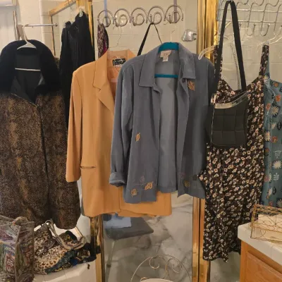 Sale Photo Thumbnail #59: Collection of women's vintage clothing and accessories, including a faux fur-trimmed animal print coat, blazers, printed dresses, and woven handbags.