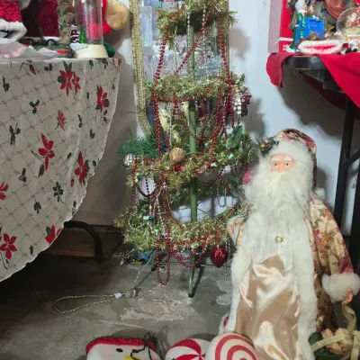 Sale Photo Thumbnail #40: Collection of Christmas decorations including a vintage wire-frame tinsel tree, Santa Claus figures, plush plush toys, and candy-themed outdoor stake lights.