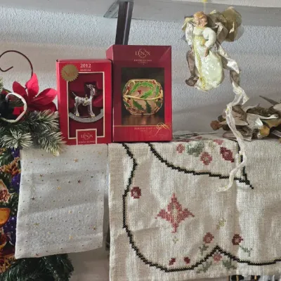 Sale Photo Thumbnail #34: Collection of holiday decor items including boxed Lenox ornaments, an angel tree topper, faux poinsettia greenery arrangement, and embroidered linens.
