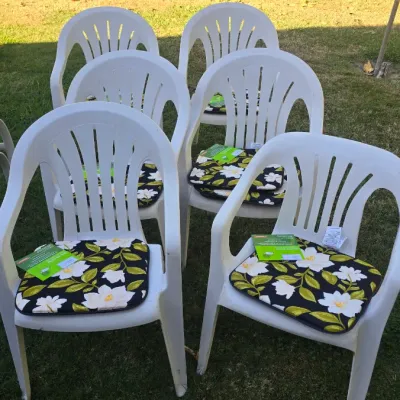 Sale Photo Thumbnail #94: Set of six white plastic lawn armchairs paired with black, green, and white floral seat cushions.