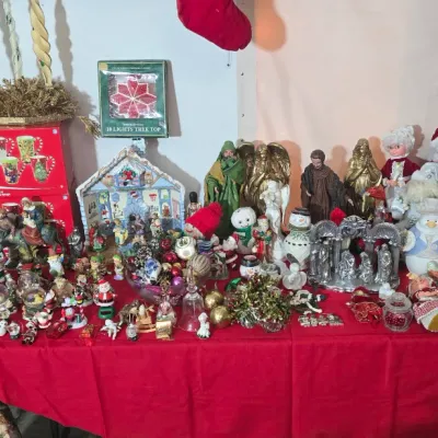 Sale Photo Thumbnail #41: A large collection of vintage Christmas decorations displayed on a table, including nativity sets, Santa figurines, snowmen, ornaments, and dolls.