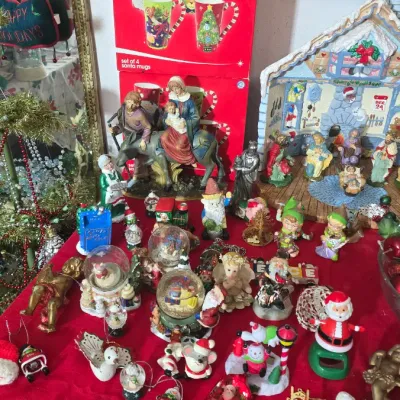 Sale Photo Thumbnail #27: Collection of Christmas decor including nativity scenes, snow globes, Santa figurines, ornaments, and boxed holiday mug sets.