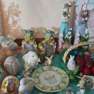 Sale Photo Thumbnail #23: Collection of vintage Easter decorations, including rabbit figurines, painted decorative eggs, an Easter-themed plate, and a wicker basket.