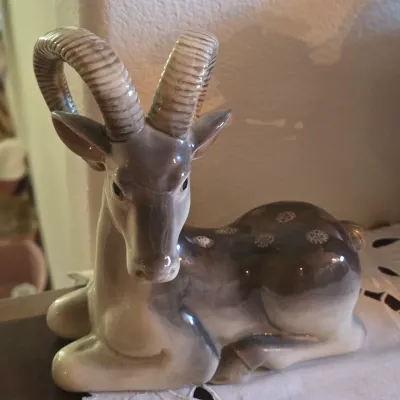 Sale Photo Thumbnail #46: Vintage Royal Copenhagen glazed porcelain figurine of a reclining ram or ibex, featuring large curved horns and detailed hand-painted accents.