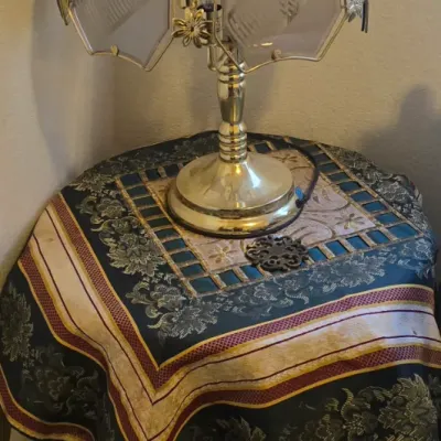 Sale Photo Thumbnail #68: Vintage brass touch lamp featuring frosted glass panel shade with floral accents, resting on a draped accent table.