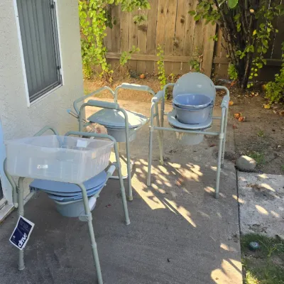 Sale Photo Thumbnail #135: Set of three Drive brand adjustable medical commode chairs set up outdoors, with additional plastic tubs resting on them.