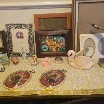 Sale Photo Thumbnail #69: Collection of decorative home accents, picture frames, and ceramic figurines including an eagle statue, swan Planter, and framed artwork.