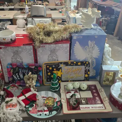 Sale Photo Thumbnail #26: Collection of vintage holiday decor, including angel figurines, festive serving platters, a small artificial Christmas tree, and novelty Santa decorations.