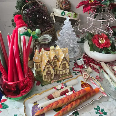 Sale Photo Thumbnail #35: Collection of holiday decorations, featuring a lighted miniature village house, clear acrylic Christmas tree, and decorative taper candles arranged on a serving tray.