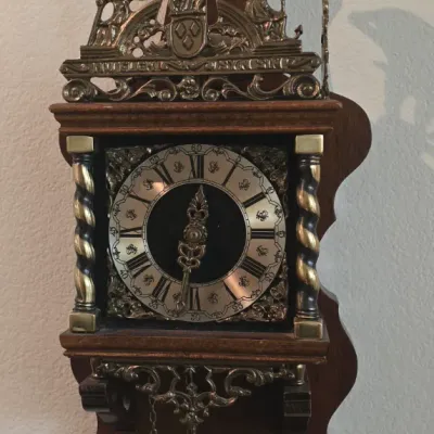 Sale Photo Thumbnail #111: Vintage Dutch Zaandam style wall clock, featuring a dark wood case, ornate brass ornamentation, and an Atlas figure holding a celestial globe at the top.