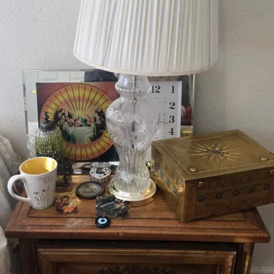 Sale Photo Thumbnail #118: Traditional wooden nightstand featuring a cut crystal table lamp with a pleated shade, paired with a brass decorative box and various small trinkets.
