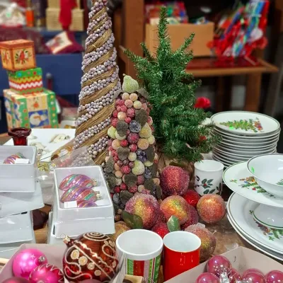 Selection of Christmas decorations, including sugared fruit topiary cones, glass ornaments, holiday dishware, and artificial tabletop trees.